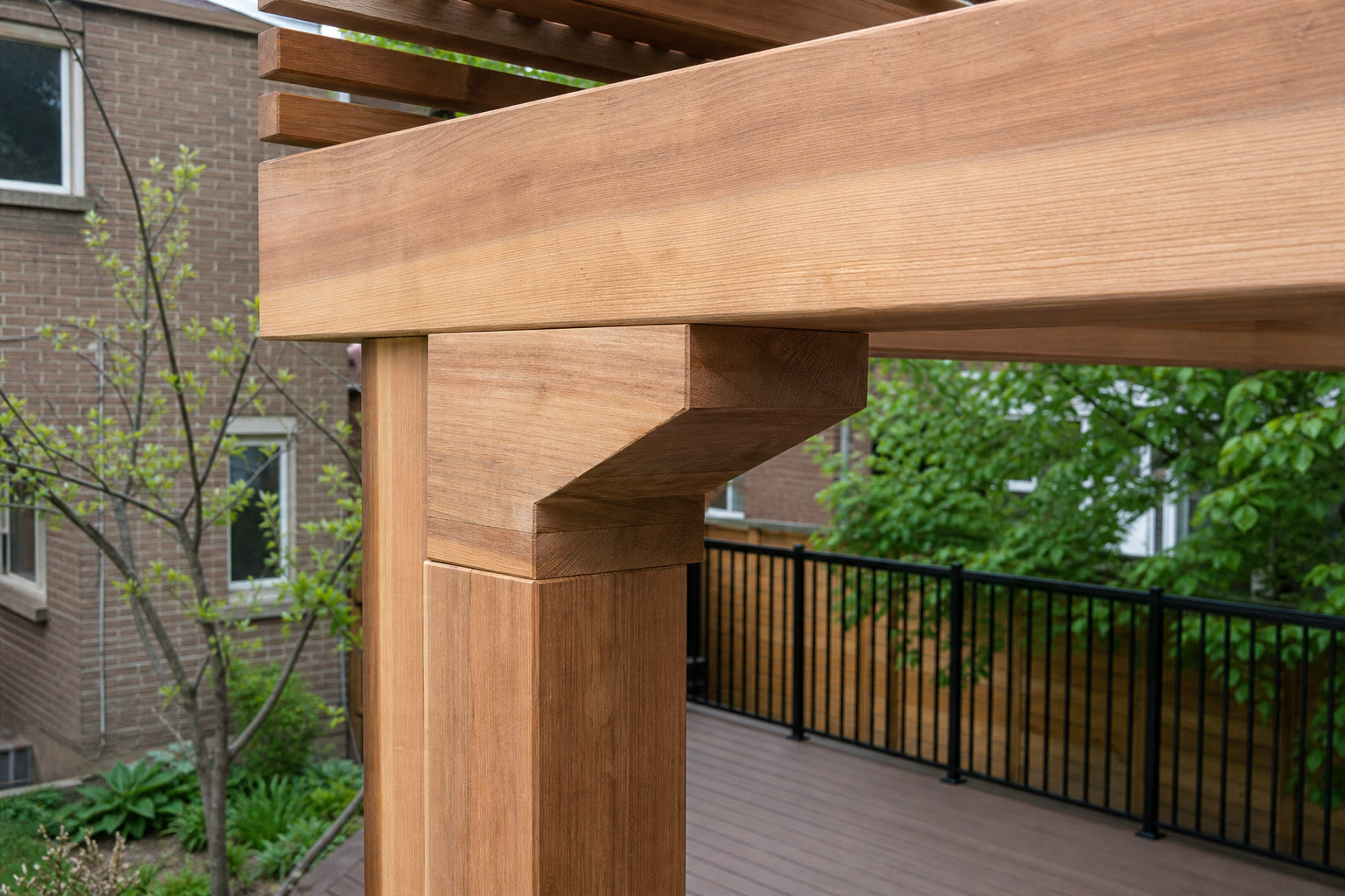 Cedar pergola beam and post joinery above a backyard deck