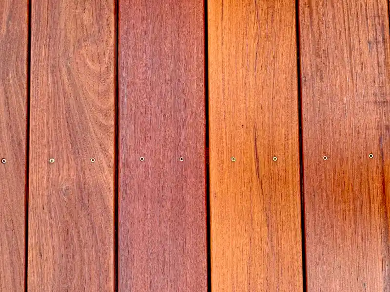 Close-up of wood deck boards fastened with aligned screws.