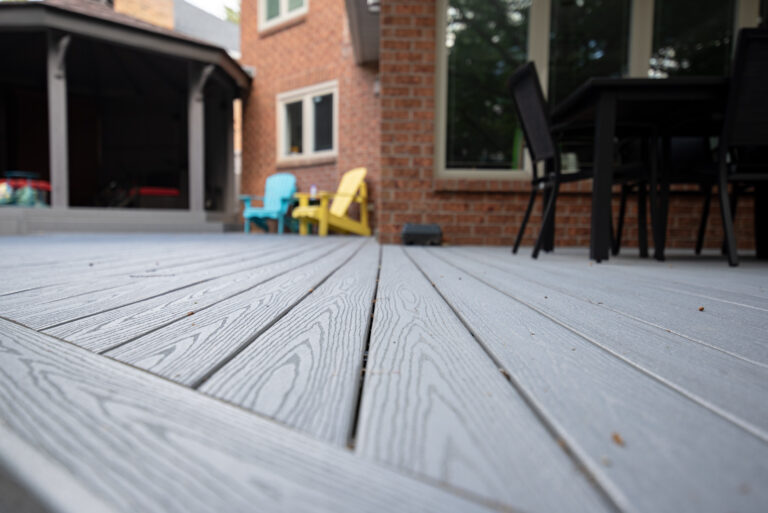 Close-up of the wood-grain texture and spacing of grey composite deck boards