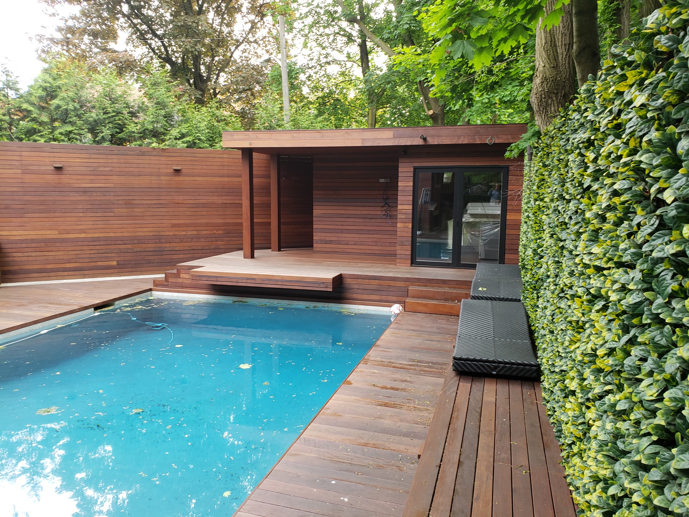 Wide view of a completed Ipe pool deck surrounding a residential swimming pool