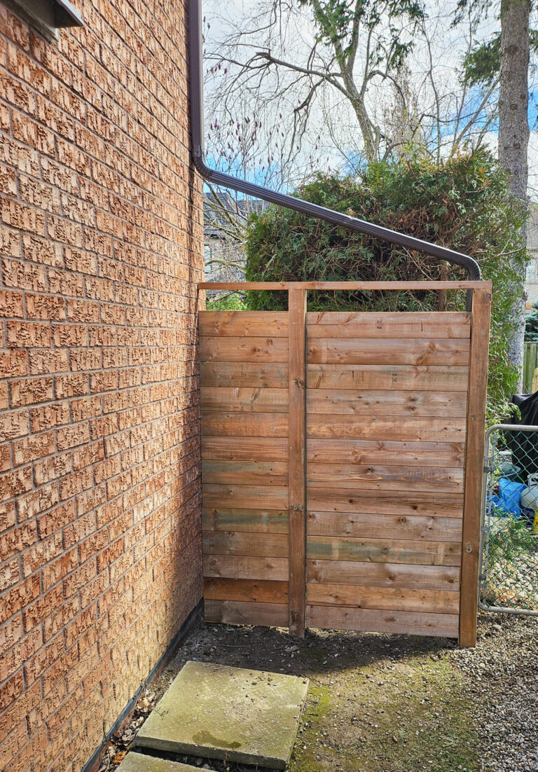 Wooden fence beside brick wall with garden view