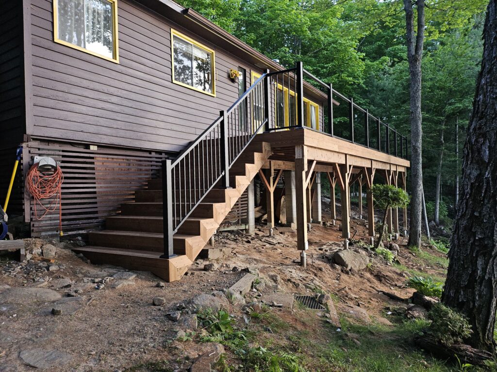 Raised backyard deck structure during construction before the decking boards are installed.